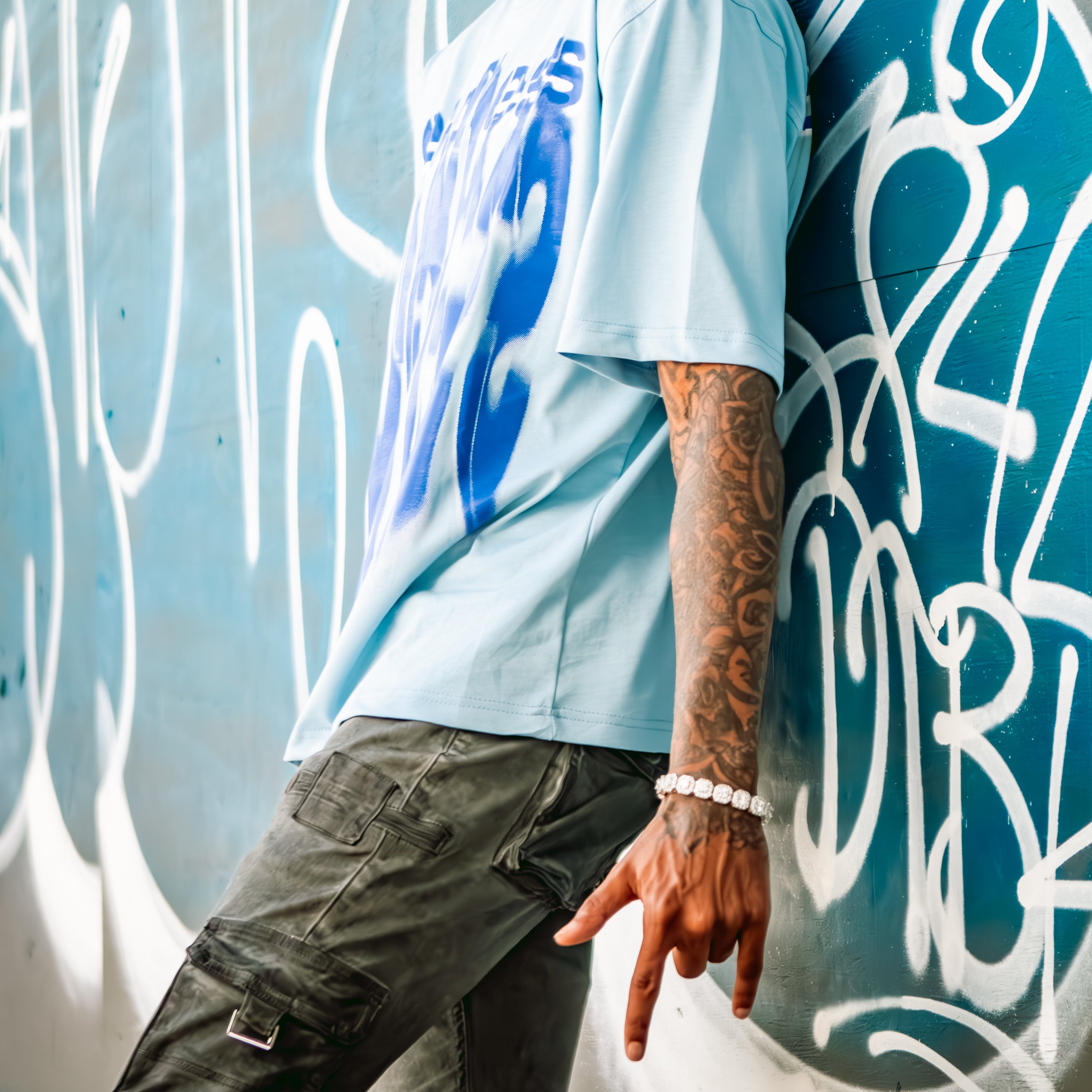 Man leaning against a graffiti-covered wall